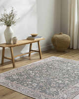 Entryway with a wood bench, woven basket, and Anando Washable Area Rug in cream, green, and pale pink. Roomscene-Rectangle