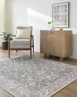 Living room scene with the Anando Washable Area Rug in cream, green, and pale pink, styled with a gray chair and wood cabinet. Roomscene-Rectangle
