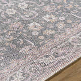Close-up of the Anando Washable Area Rug. Features a traditional floral pattern in cream, pink, and green hues. Texture