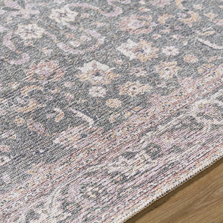 Close-up of the Anando Washable Area Rug. Features a traditional floral pattern in cream, pink, and green hues. Texture