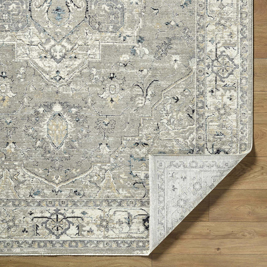 Close-up of Ayzize Beige Area Rug showing traditional, farmhouse design, polyester material, and beige, charcoal, and ivory colors. Fold
