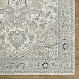 Close up of the Ayzize Ivory Area Rug showing its traditional charcoal, ivory, and blue floral pattern and texture. Corner