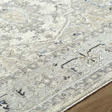 Close-up of the Ayzize Ivory Area Rug showing its farmhouse traditional pattern and soft charcoal, blue, and taupe colors. Texture