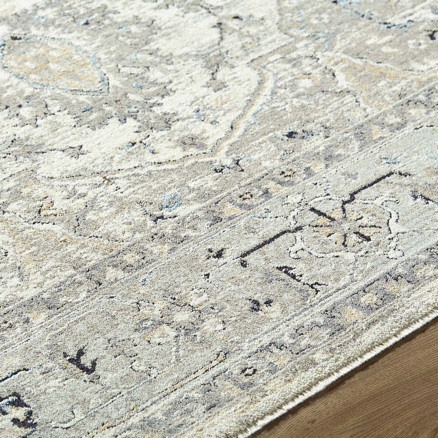 Close-up of the Ayzize Ivory Area Rug showing its farmhouse traditional pattern and soft charcoal, blue, and taupe colors. Texture