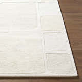 Close-up of the hand-tufted Antwan Area Rug. Cream and beige wool rug with a contemporary geometric pattern. Front