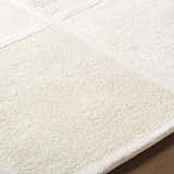 Close up of the hand-tufted Antwan Area Rug. Beige and cream wool rug with a contemporary geometric pattern. Texture
