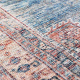 Close-up of the Baltinglass Rust & Blue Washable Area Rug, showing its traditional pattern and chenille texture. Texture