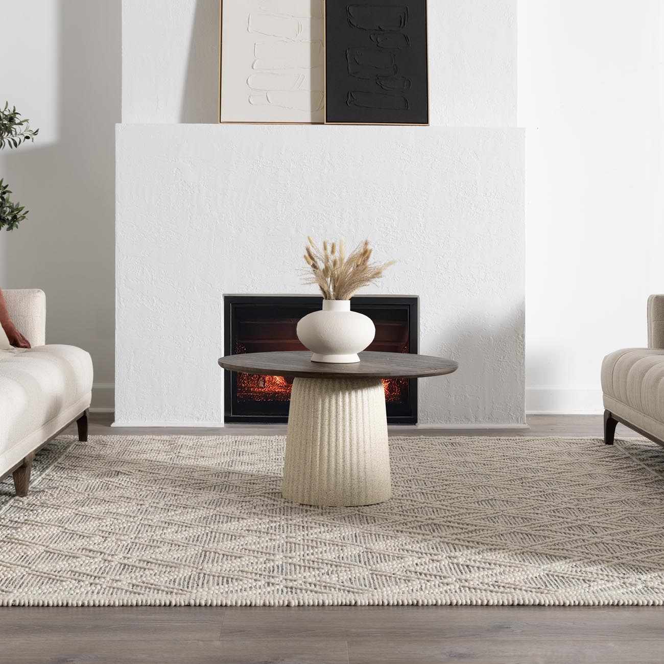 Living room scene with a geometric ivory and black Ramsbury Wool Area Rug under a round coffee table. Roomscene-Rectangle