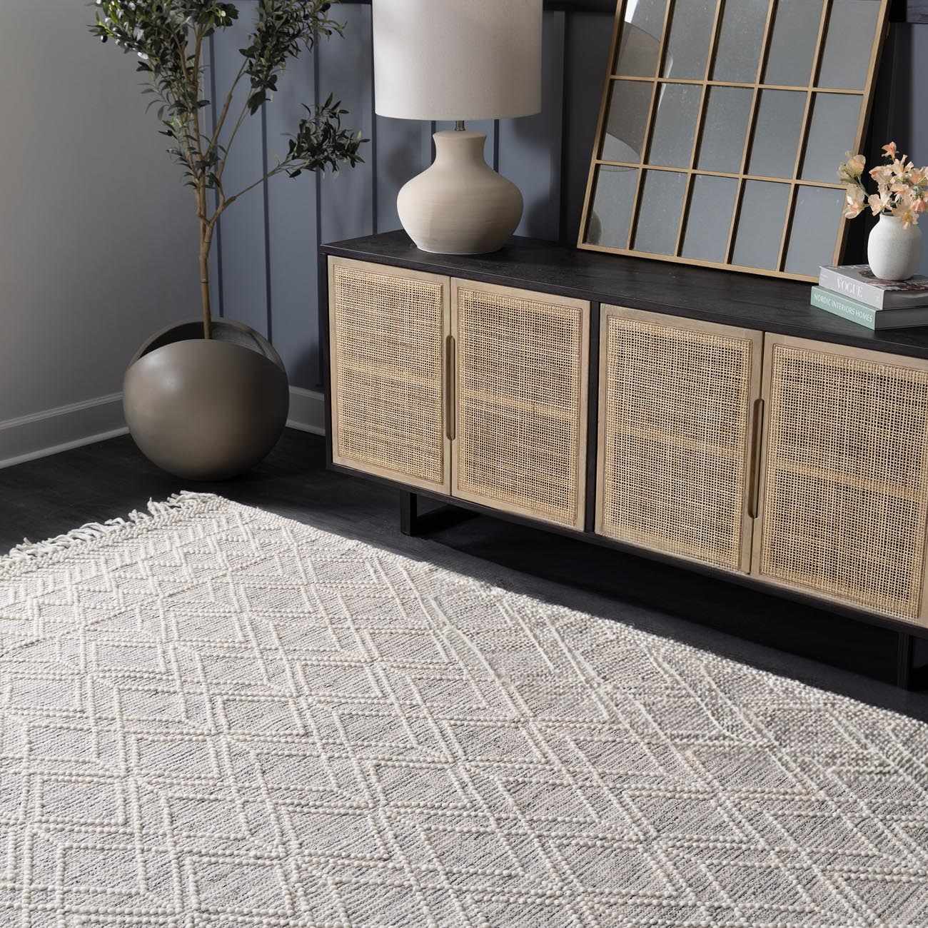 Living room scene with ivory Ramsbury Wool Area Rug, geometric pattern, under a console table with lamp and decor. Roomscene-Rectangle