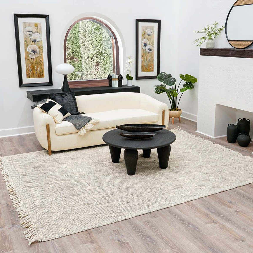 Living room scene with ivory Ramsbury Wool Area Rug, cream chaise lounge, and black accents. Roomscene-Rectangle