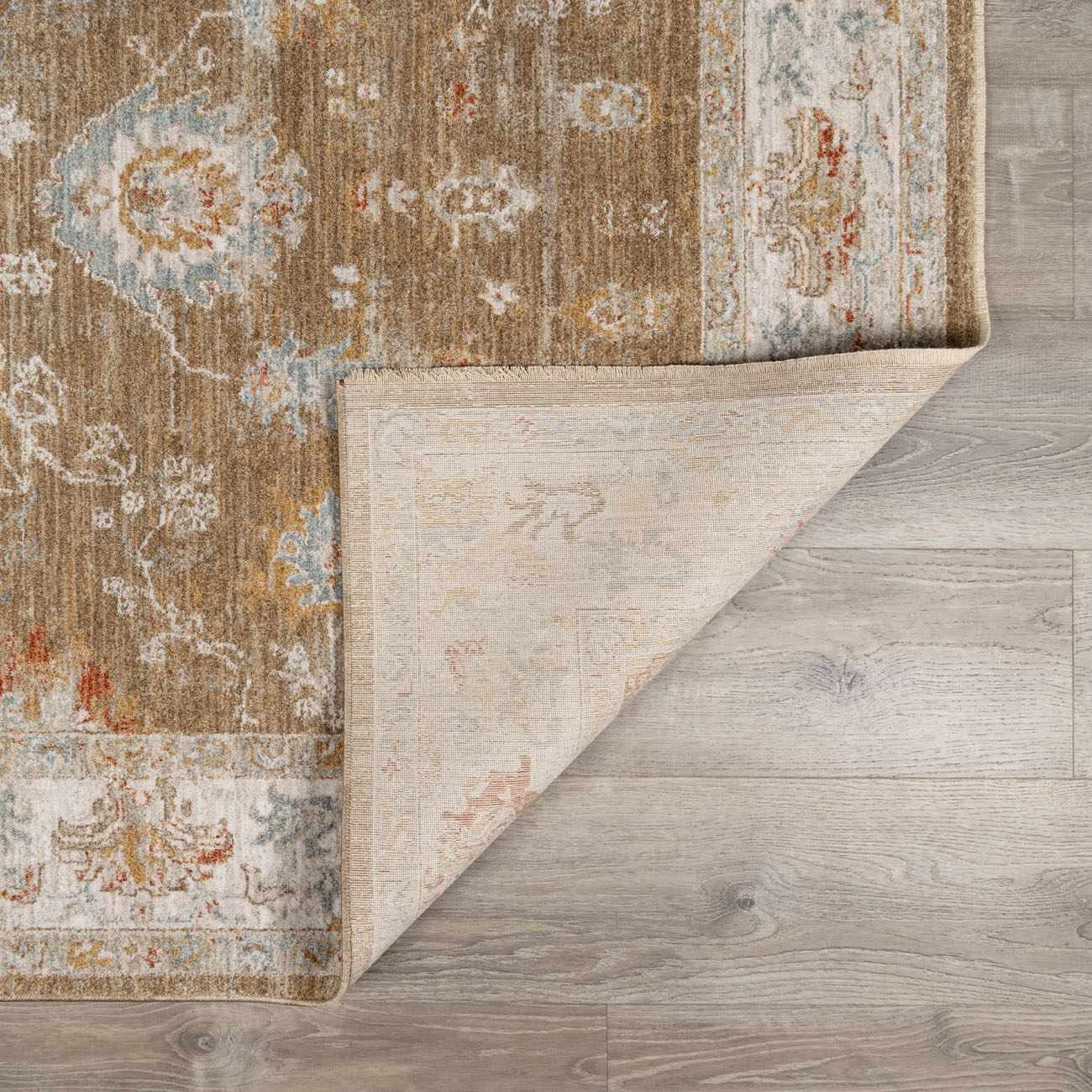 Close-up of the brown Rangeville Thick Luxe Statement Rug showing its traditional floral pattern and soft, plush texture. Fold