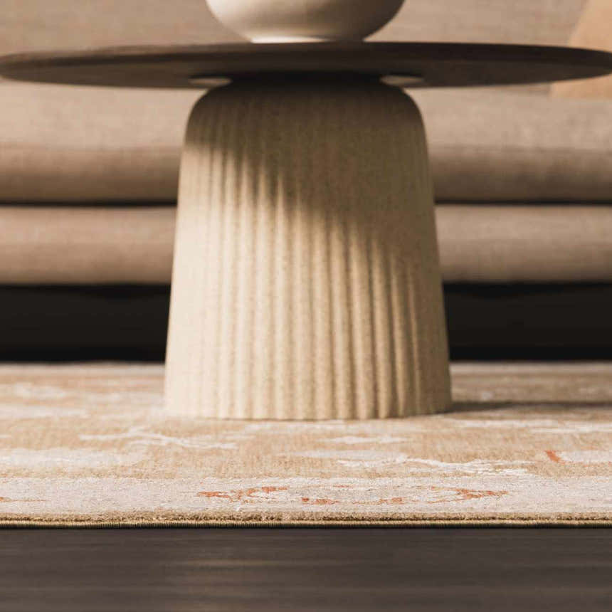 Close-up of the beige Rangeville Thick Luxe Statement Rug with a subtle orange pattern under a modern coffee table. Styleshot