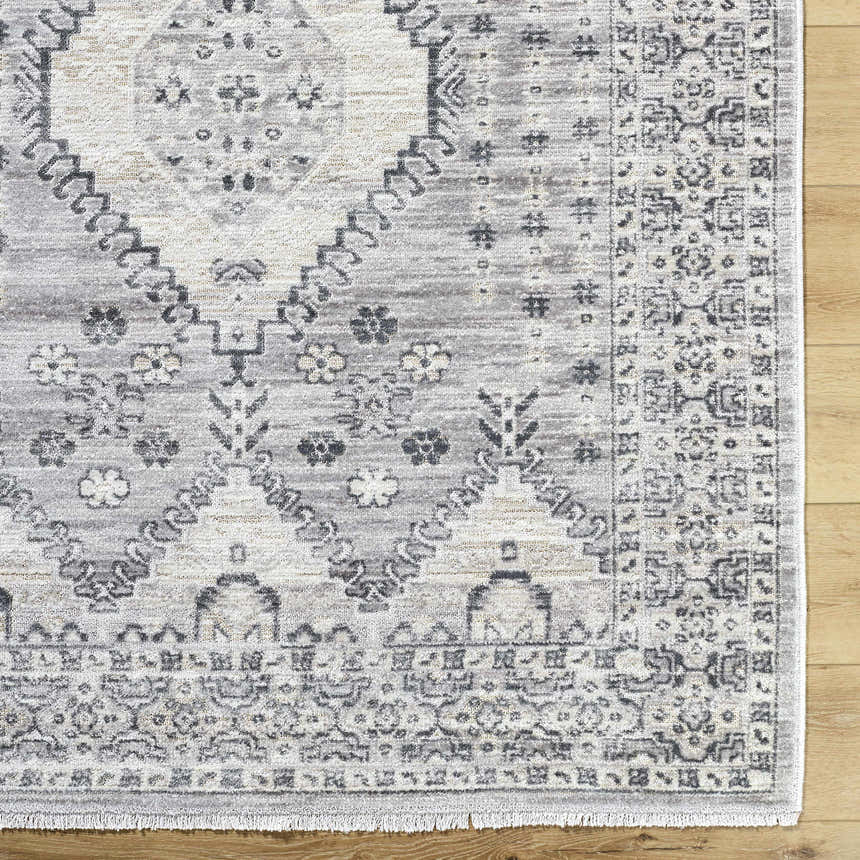Close-up of the Aoibhe Area Rug. Ivory, medium gray, and slate gray traditional floral pattern. Corner