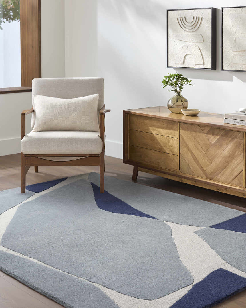 Living room with a modern wood cabinet and chair on the Robbins Modern Blue Wool Rug. Roomscene-Rectangle