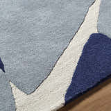Close-up of the Robbins Modern Blue Wool Rug, featuring a geometric pattern in blue, light slate, and white. Texture
