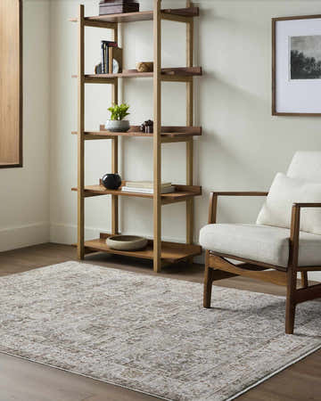 Living room scene with a cream armchair and the taupe Wyeth Area Rug on hardwood floors. Roomscene-Rectangle