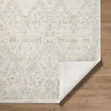 Close-up of the Almaas Cream rug showing its traditional pattern and luxe texture on a wood floor. Fold