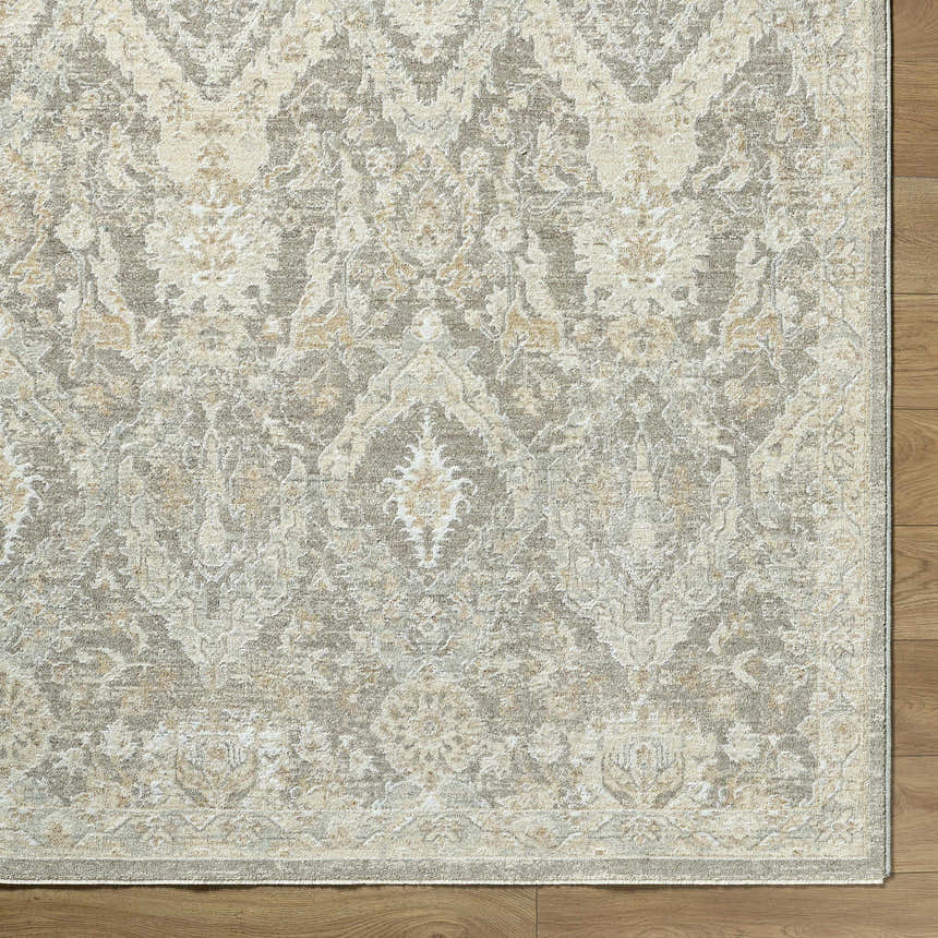 Close-up of the Almaas Medium Gray rug showing its traditional floral pattern and soft texture on a wood floor. Corner
