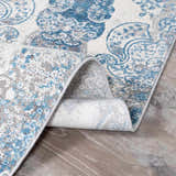 Close-up of Rydalmere Luxury Ultra Soft Rug. Blue and gray paisley pattern on a soft, textured rug. Fold