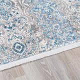 Close-up of the Rydalmere Luxury Ultra Soft Rug. Features a traditional blue and gray floral pattern on a light wood floor. Pile