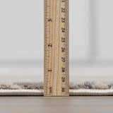 Close up of the Garza Diamond Textured Washable Rug pile height, showing a beige and gray diamond pattern. Pile