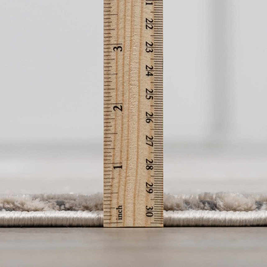 Close up of the Garza Diamond Textured Washable Rug pile height, showing a beige and gray diamond pattern. Pile