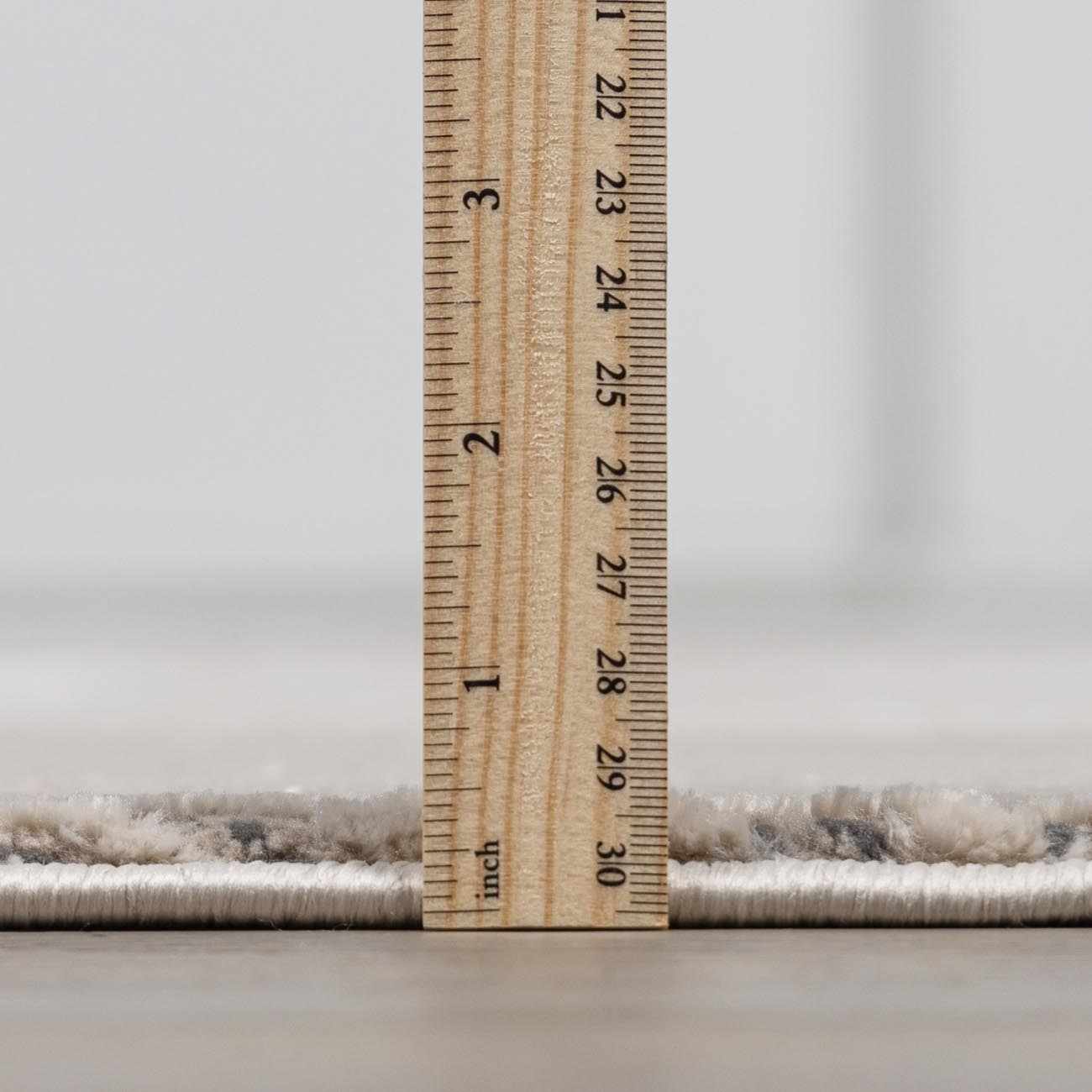 Close up of the Garza Diamond Textured Washable Rug pile height, showing a beige and gray diamond pattern. Pile