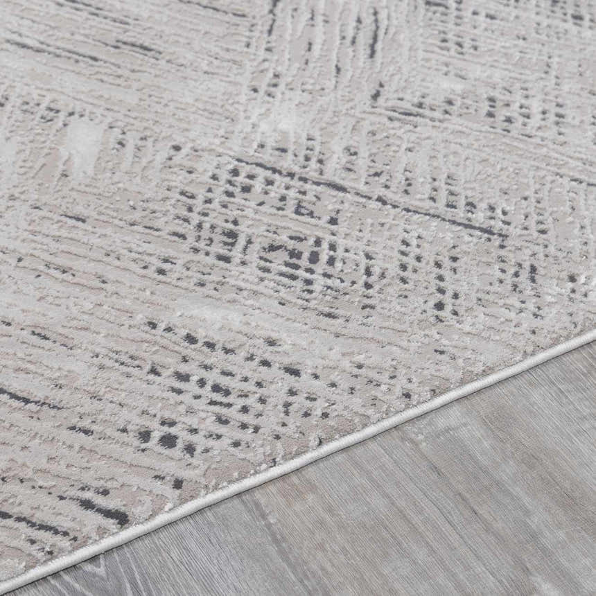 Close-up of the Garza Diamond Textured Washable Rug showing beige, gray, and charcoal diamond pattern and soft texture. Pile
