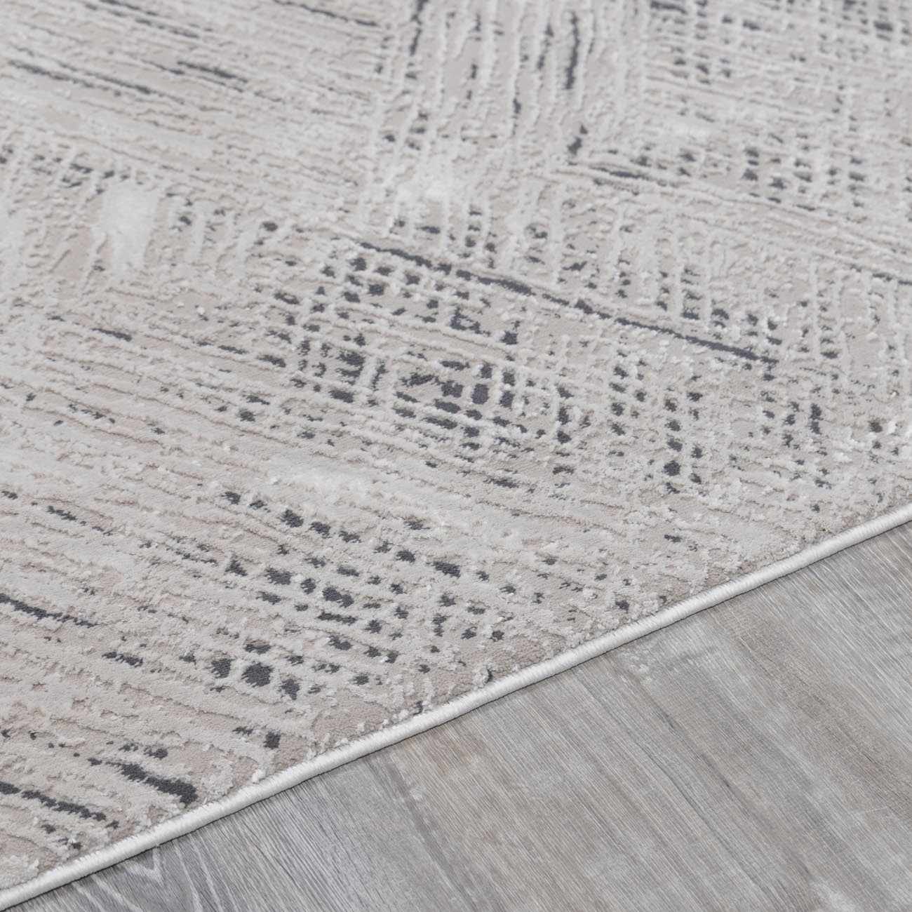 Close-up of the Garza Diamond Textured Washable Rug showing beige, gray, and charcoal diamond pattern and soft texture. Pile