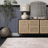 Living room scene with a beige Garza Diamond Textured Washable Rug, dark wood floors, and a modern cabinet with a lamp and mirror. Roomscene-Rectangle