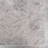 Close-up of the Garza Diamond Textured Washable Rug. Beige rug with a contemporary diamond and line pattern. Swatch