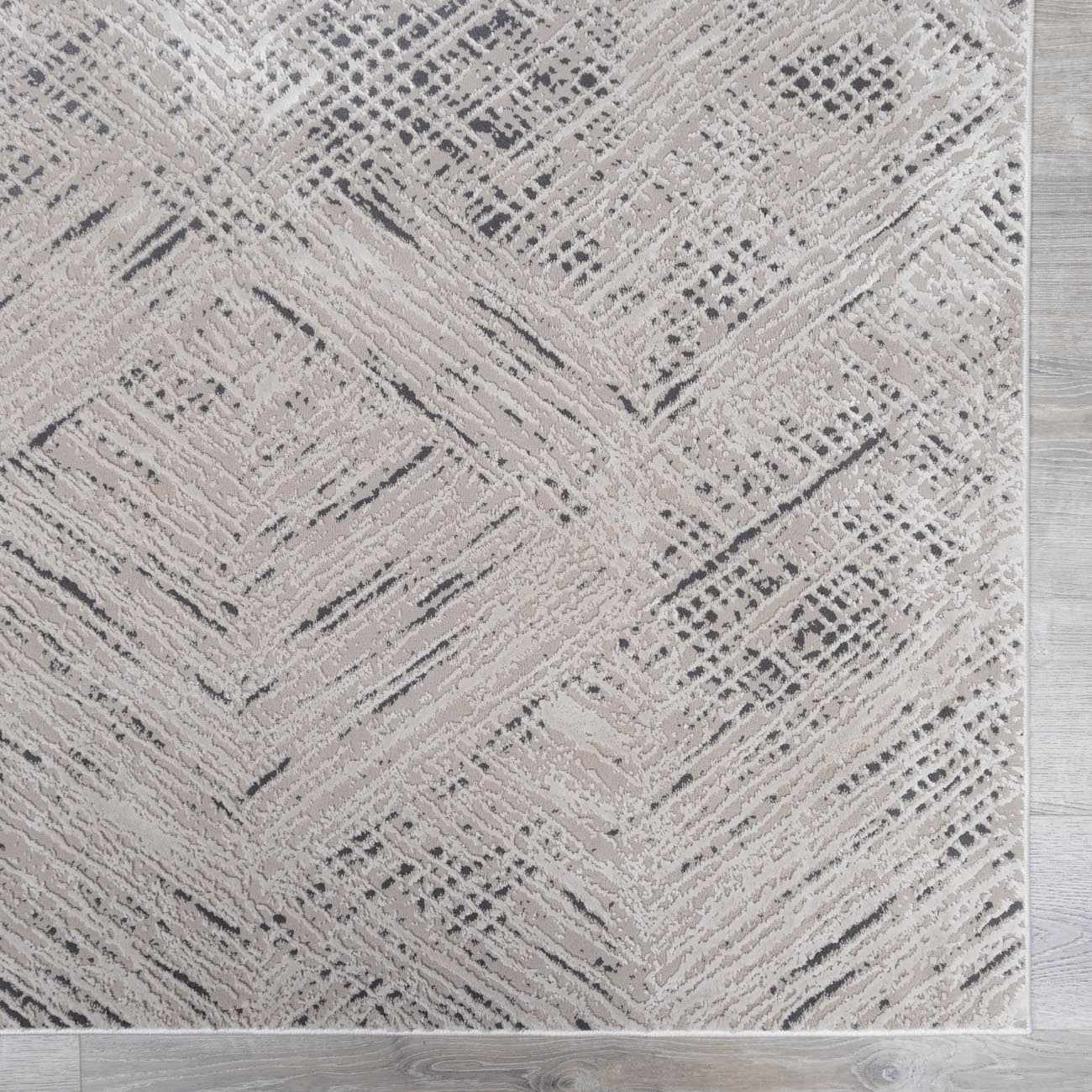 Close-up of the Garza Diamond Textured Washable Rug. Beige rug with a contemporary diamond and line pattern. Swatch