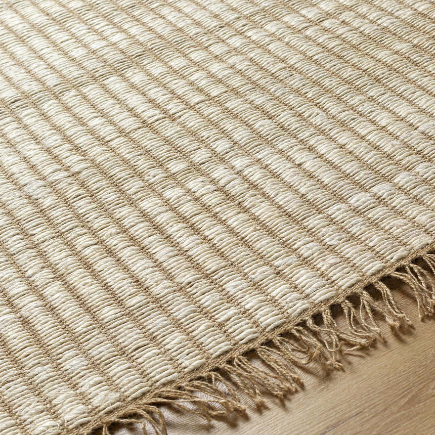 Close-up of the beige Mihal Area Rug showing its jute texture, hand woven construction, and fringe detail. Texture
