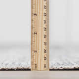 Close-up of the Barny Gray Blue Washable Rug pile height, showing its soft, low-pile texture with a ruler. Pile