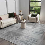 Living room scene with a Barny Gray Blue Washable Rug, white sofa and chair, and a round coffee table. Roomscene-Rectangle