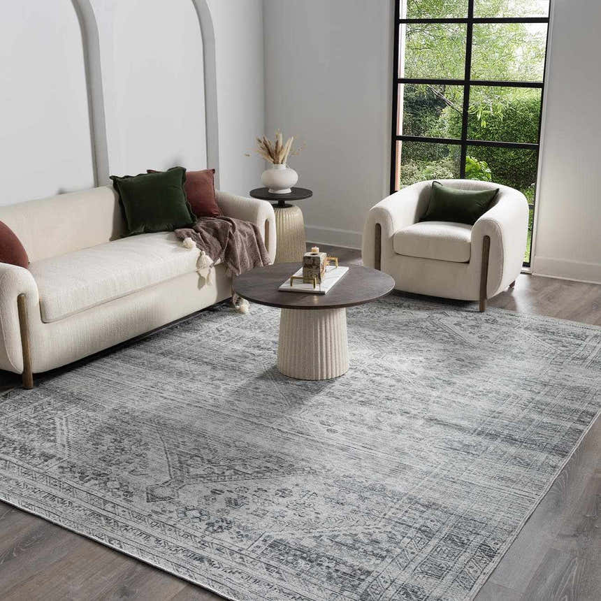 Living room scene with a Barny Gray Blue Washable Rug, white sofa and chair, and a round coffee table. Roomscene-Rectangle