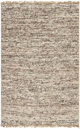 Close-up of the Tan Gopi Area Rug. Hand woven jute and wool rug in neutral tan, taupe, and black with fringe detail. Design-Rectangle-576