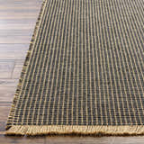 Close-up of Kimi Machine Woven Becki Owens x LIVABLISS rug showing black and light brown grid pattern and jute texture. Front