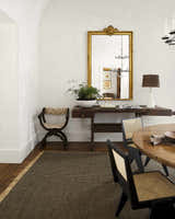 Farmhouse dining room with Kimi Machine Woven Becki Owens x LIVABLISS rug, wood table, and gold mirror. Styleshot