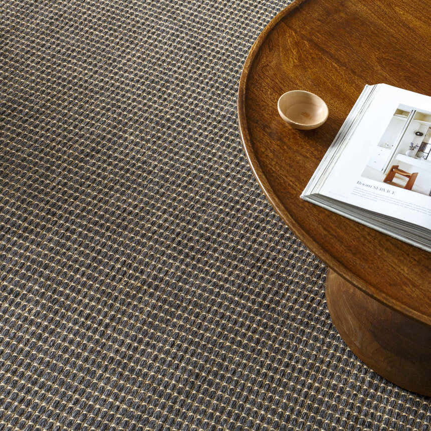 Close-up of the Kimi Machine Woven Becki Owens x LIVABLISS rug, showing its black and light brown woven texture. Styleshot
