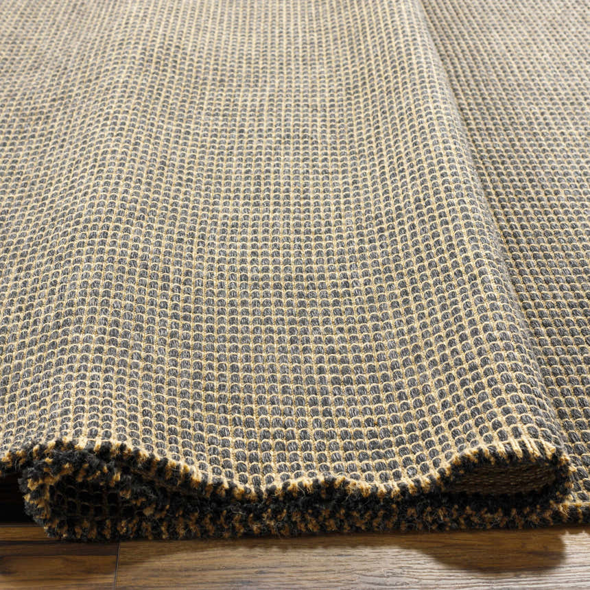 Close-up of Kimi Machine Woven Becki Owens x LIVABLISS rug. Black and light brown jute texture, machine woven. Texture