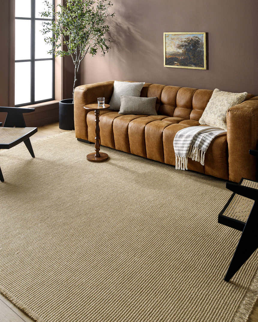 Living room scene with a brown leather sofa and Kimi Machine Woven Becki Owens x LIVABLISS rug in light brown. Roomscene-Rectangle