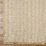 Close-up of the Kimi Machine Woven Becki Owens x LIVABLISS BOKM-2306 Area Rug. Tan and light brown jute texture. Corner
