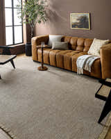 Living room with tan Kimi Machine Woven Becki Owens x LIVABLISS rug, brown couch, and black chairs. Farmhouse style. Roomscene-Rectangle