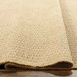 Close-up of the light brown Kimi Machine Woven Becki Owens x LIVABLISS jute rug showing texture and construction. Texture