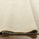 Close-up of Kimi Machine Woven Becki Owens x LIVABLISS rug showing gray and light brown jute texture. Texture