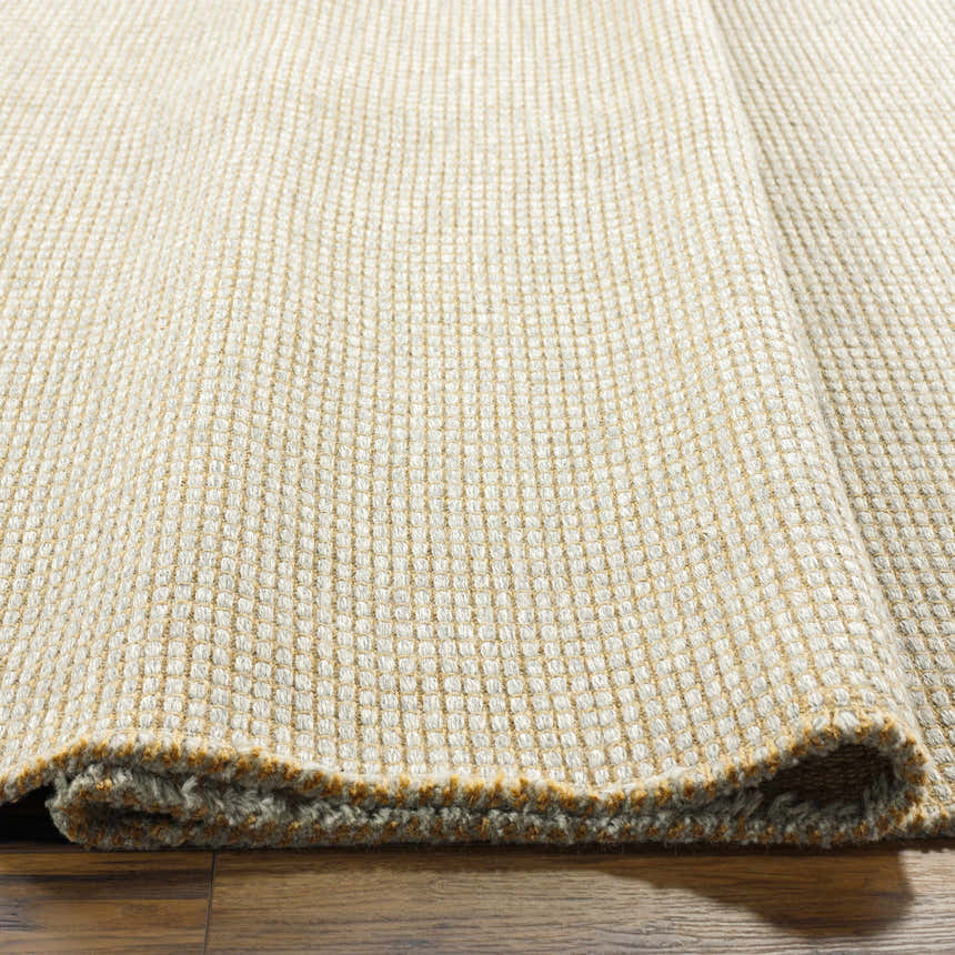 Close-up of Kimi Machine Woven Becki Owens x LIVABLISS rug showing gray and light brown jute texture. Texture