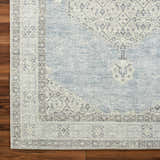 Close-up of the Lila Medallion Denim Area Rug showing its farmhouse style medallion pattern and soft charcoal and gray tones. Corner
