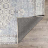 Close-up of the Lila Medallion Denim Area Rug showing its farmhouse style, medallion pattern, and gray, blue, and nutmeg hues. Fold