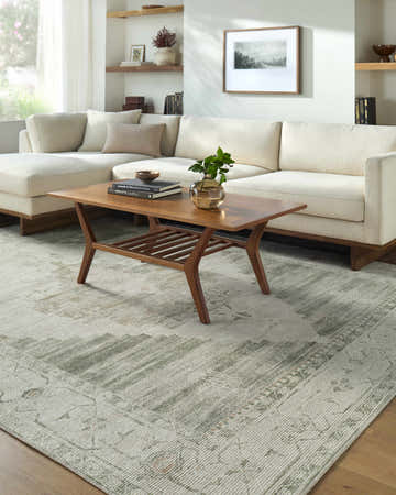Living room scene with a Luca Medallion Sage Area Rug, cream sectional sofa, and mid-century modern wood coffee table. Roomscene-Rectangle